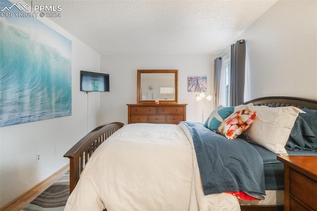 bedroom featuring a textured ceiling and hardwood / wood-style flooring