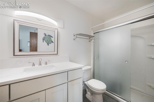 bathroom featuring vanity, toilet, and an enclosed shower