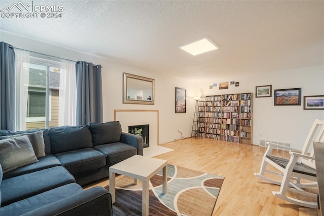 living room with wood-type flooring and a textured ceiling