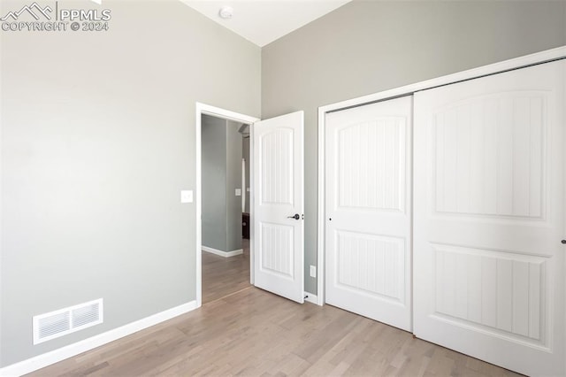 unfurnished bedroom featuring light hardwood / wood-style flooring and a closet