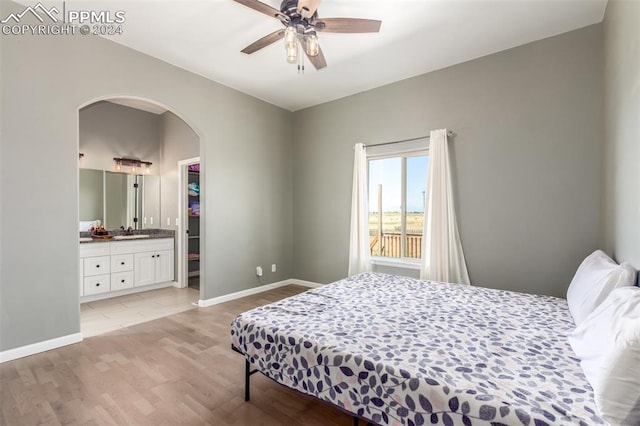 bedroom featuring light hardwood / wood-style flooring, connected bathroom, ceiling fan, and sink