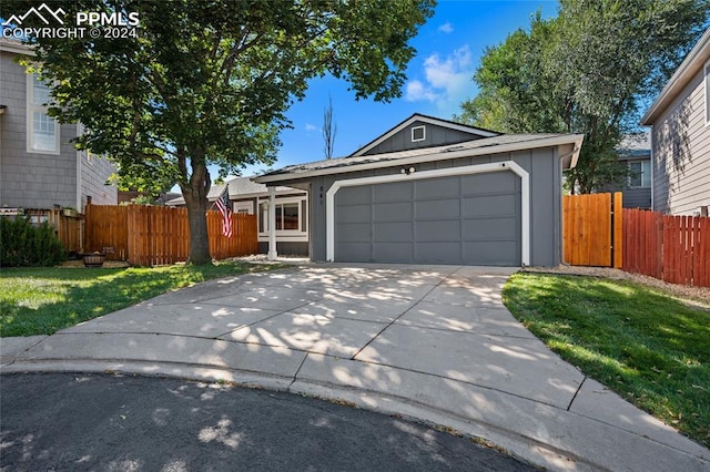 ranch-style house featuring a garage and a front lawn