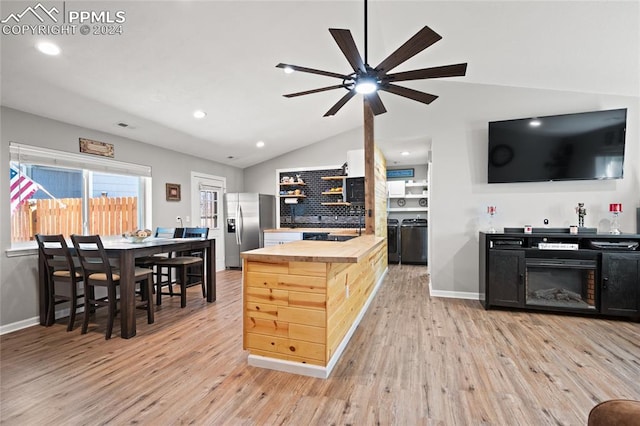 kitchen featuring stainless steel fridge, light hardwood / wood-style floors, butcher block counters, lofted ceiling, and ceiling fan