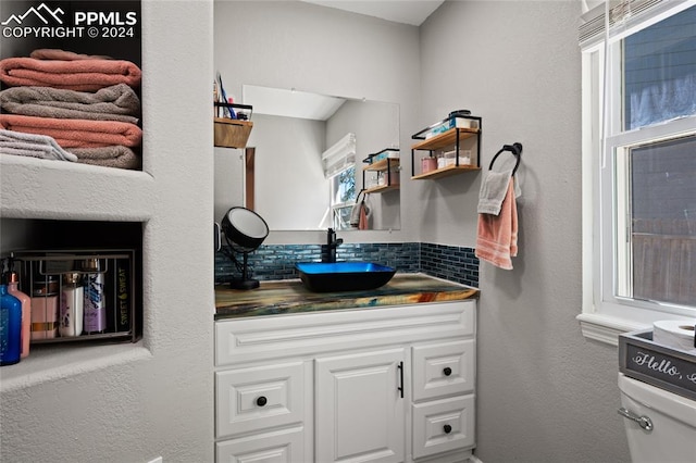 bathroom featuring backsplash, vanity, and toilet