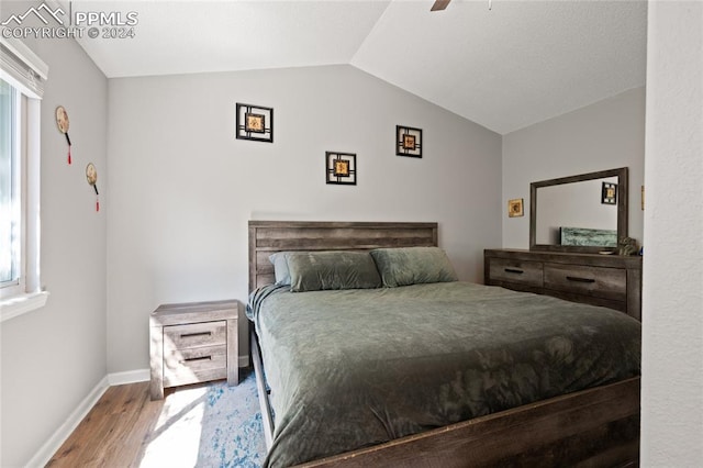 bedroom featuring ceiling fan, wood-type flooring, lofted ceiling, and multiple windows