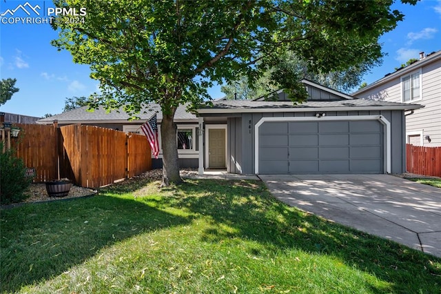 view of front of home with a front yard and a garage