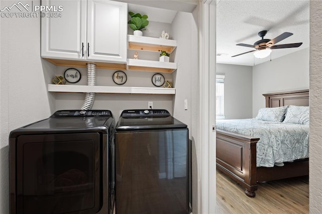 washroom featuring light hardwood / wood-style floors, a textured ceiling, ceiling fan, cabinets, and washer and dryer