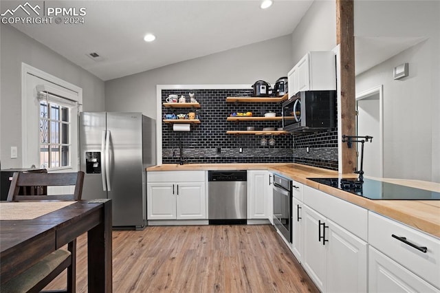 kitchen featuring light wood-type flooring, white cabinetry, vaulted ceiling, and stainless steel appliances