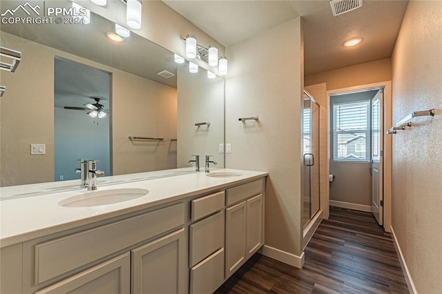 bathroom featuring wood-type flooring, vanity, a shower with shower door, and ceiling fan