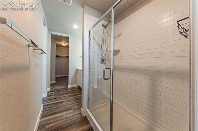 bathroom featuring wood-type flooring and a shower with shower door