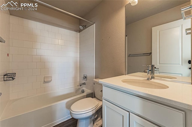 full bathroom featuring hardwood / wood-style floors, vanity, toilet, and tiled shower / bath