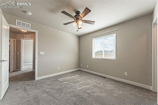 unfurnished room with a textured ceiling, carpet flooring, and ceiling fan