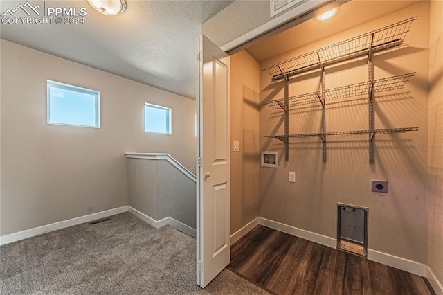 clothes washing area featuring washer hookup, hookup for an electric dryer, a textured ceiling, and dark hardwood / wood-style flooring