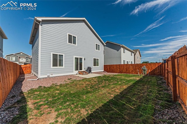 rear view of property with a yard and a patio area