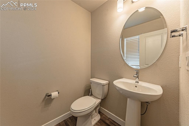 bathroom featuring hardwood / wood-style floors and toilet