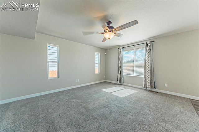 carpeted spare room with a textured ceiling and ceiling fan