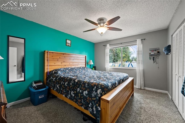 carpeted bedroom with ceiling fan, a textured ceiling, and a closet