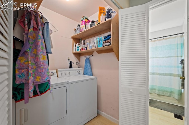 laundry area with washer and clothes dryer and light hardwood / wood-style floors