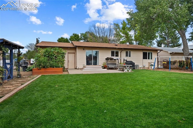 rear view of house with a yard and a patio