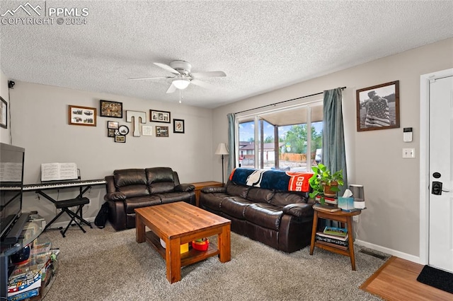 carpeted living room featuring ceiling fan and a textured ceiling