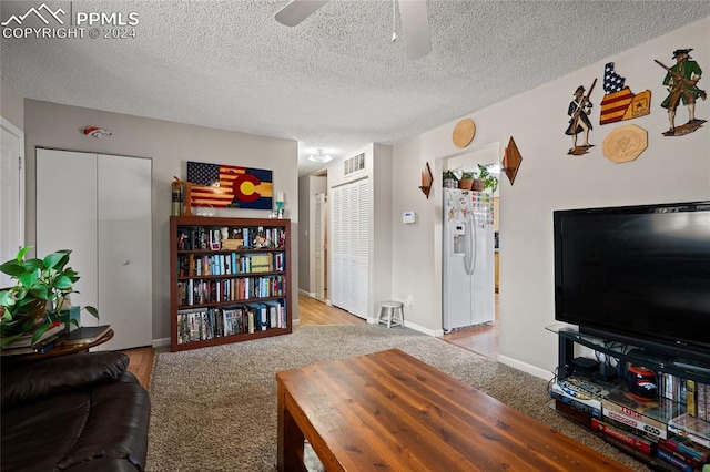 carpeted living room with a textured ceiling and ceiling fan