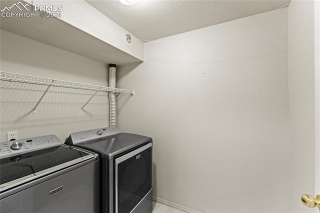 laundry room with washer and clothes dryer and a textured ceiling