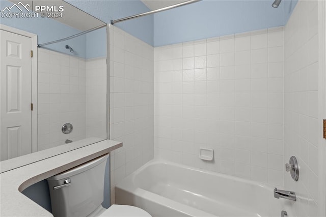 bathroom featuring tiled shower / bath combo and toilet