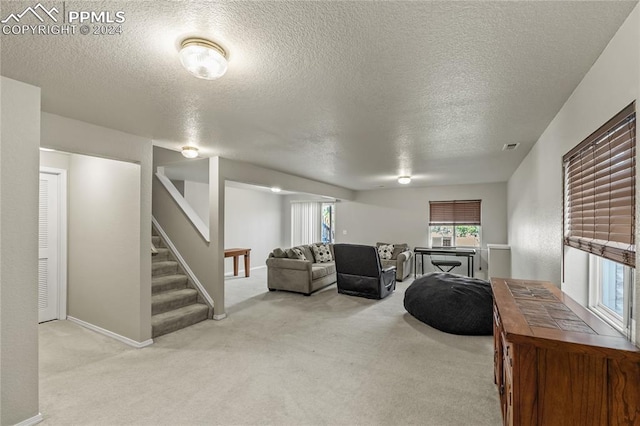 living room with a textured ceiling and light colored carpet