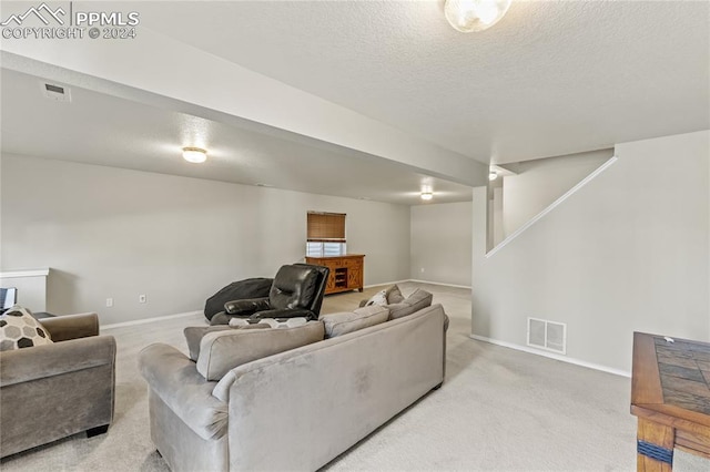 living room with a textured ceiling and light carpet