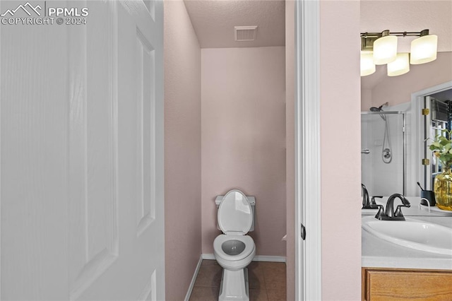 bathroom featuring a shower, vanity, a textured ceiling, tile patterned flooring, and toilet