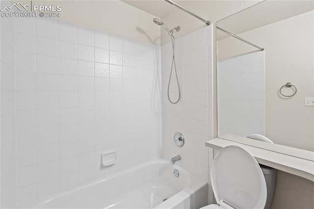 bathroom featuring tiled shower / bath and toilet