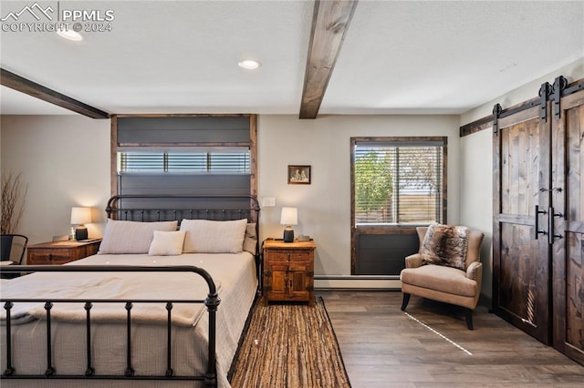 bedroom with beamed ceiling, baseboard heating, hardwood / wood-style floors, and a barn door