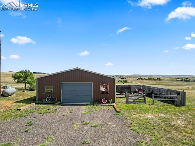 view of outdoor structure featuring a rural view and a garage