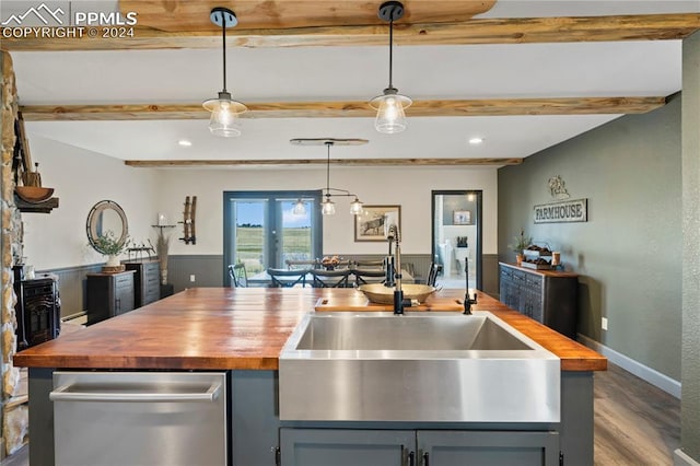 kitchen with wood counters, sink, beam ceiling, decorative light fixtures, and hardwood / wood-style floors