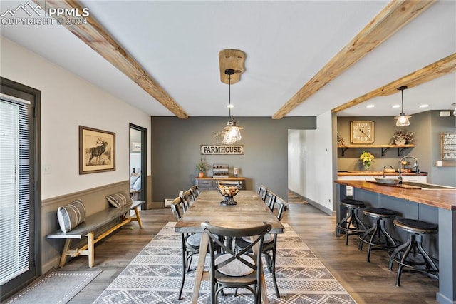 dining area featuring beam ceiling, dark hardwood / wood-style floors, and sink