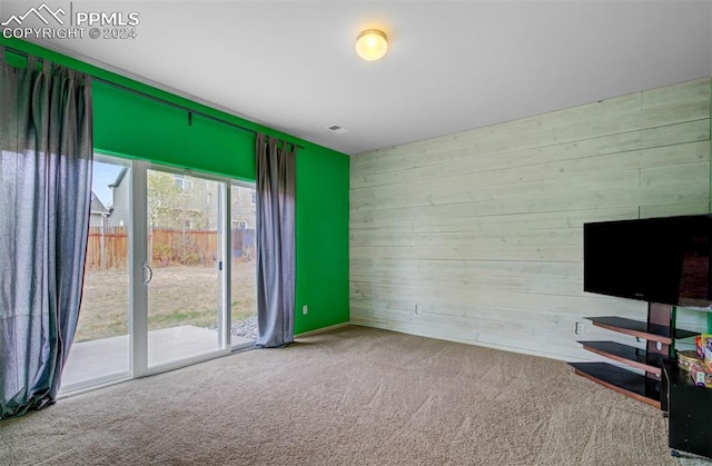 interior space featuring carpet floors and wooden walls