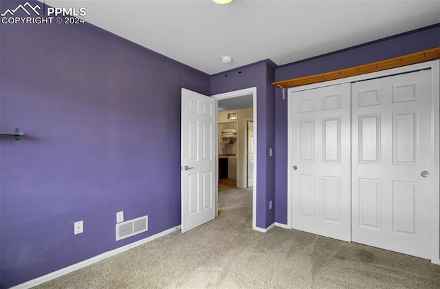 unfurnished bedroom featuring carpet and a closet