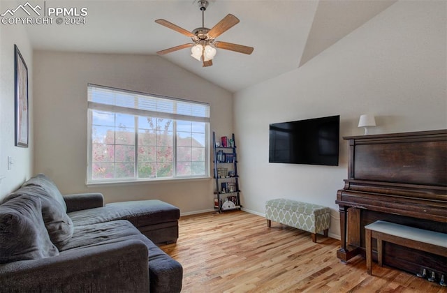 living room with ceiling fan, lofted ceiling, and light hardwood / wood-style flooring