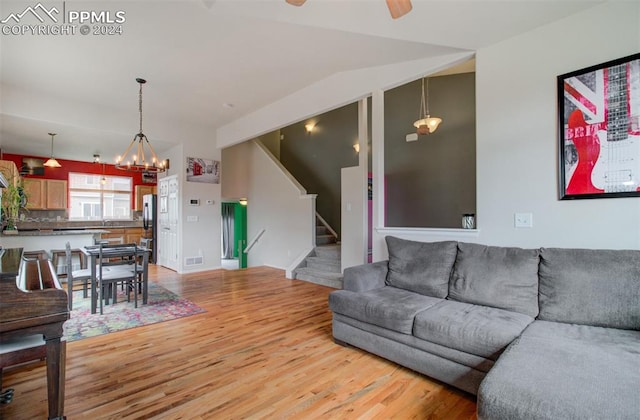 living room featuring light hardwood / wood-style floors and ceiling fan with notable chandelier