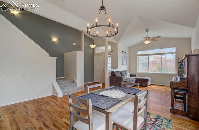 dining space featuring ceiling fan with notable chandelier, lofted ceiling, and light wood-type flooring