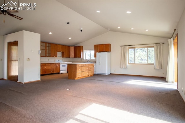 kitchen featuring white appliances, a center island, vaulted ceiling, and light colored carpet