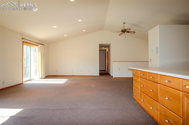 unfurnished living room with vaulted ceiling, dark colored carpet, and ceiling fan