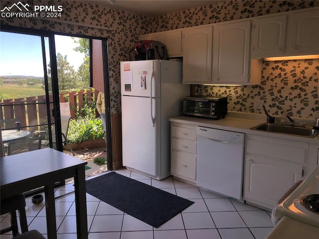 kitchen with white cabinets, white appliances, light tile patterned floors, and sink