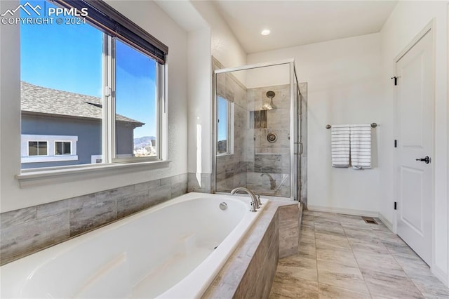 bathroom featuring shower with separate bathtub