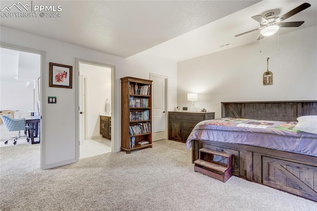 bedroom with light colored carpet, ensuite bath, and ceiling fan