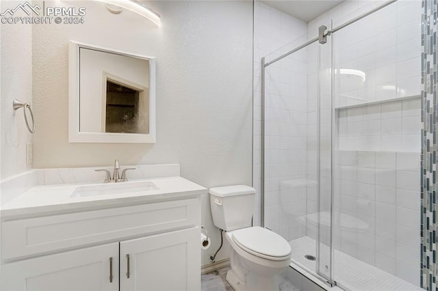 bathroom with vanity, toilet, and a shower with shower door