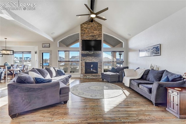 living room featuring a fireplace, ceiling fan with notable chandelier, light hardwood / wood-style floors, and plenty of natural light