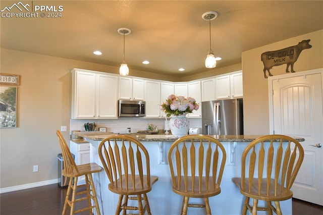 kitchen with dark stone counters, stainless steel appliances, and white cabinetry