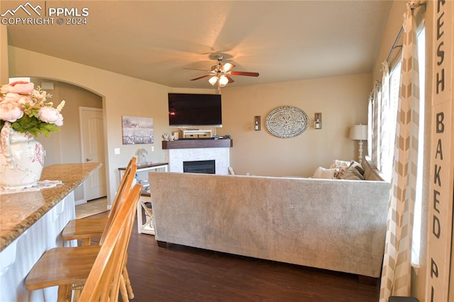 living room with ceiling fan and dark wood-type flooring