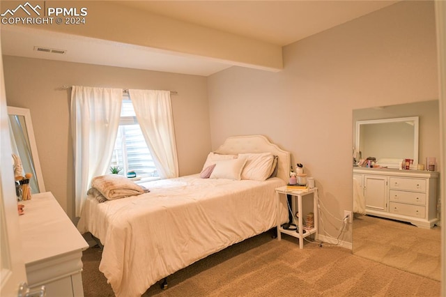 carpeted bedroom with beam ceiling